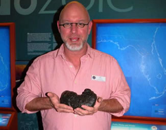  South Florida Museum Director of Education Jeff Rodgers holds "Precious," the largest coprolite, or "dungstones," in this world record collection.