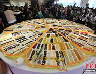 People gather around the giant cake of 3.29 meters in diameter in Nanjing, east China's Jiangsu province. A group of chefs in Nanjing, East China's Jiangsu province have set a world record for baking the "richest fruit cake" with the most ingredients. The Giant cake, 3.29 meters in diameter, was made with 329 ingredients, including strawberry, mango, grape and ginseng fruit.