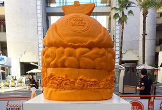  The sculpture was carved over 30 hours from a one-ton block of 100 percent aged Wisconsin cheddar cheese. Debuting on National Cheeseburger Day (Sept. 18) at Los Angeles' popular Hollywood & Highland, the final sculpture measures in at 45 inches in height, 38 inches in width, and 1,524 pounds ? 599 pounds more than the previous record-holding sculpture. 