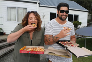Customers eating their drone delivered pizza. Fast food company Domino's had used an unmanned aerial vehicle to deliver two pizzas?one piri piri chicken pizza and one cranberry chicken pizza?to a customer in Whangaparaoa, a town north of Auckland. 