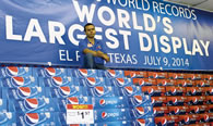 Photo: Israel Vasquez, store manager Food King is shown with the World's Largest Packaged Product Display. Photo: María Cortés González.
