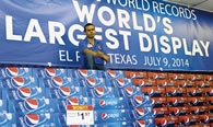 Photo: Israel Vasquez, store manager Food King is shown with the World's Largest Packaged Product Display. Photo: María Cortés González.