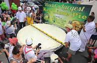 Photo: Chefs Paul Menta, left, and Jim Brush, right, measure a giant Key lime pie Friday, July 4, 2014, in Key West, Fla. The gargantuan pastry, measuring 9 feet, 2 inches in diameter, was the centerpiece of the Key Lime Festival that concludes Saturday, July 5. The pie’s ingredients included juice from 6,480 Key limes, 60 gallons of sweetened condensed milk and 220 pounds of graham crackers. Photo: AP Photo/Florida Keys News Bureau, Rob O’Neal