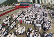 People make dumplings simultaneously at a square in Fusong county of Baishan, Northeast China's Jilin province on September 1, 2014. The event saw a total of 2,943 people take part in what is the Guinness World Records attempt for "largest cookery lesson."