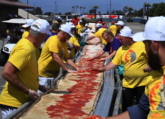 Volunteers at the Auto Club Speedway in Fontana, California, made the longest pizza with a length of 1.32 miles (2.13 kilometers). Approximately 17,700 lbs. of dough, 5,000 lbs. of tomato sauce and 3,900 lbs. of mozzarella cheese were used to create the longest pizza.