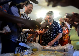  Crown Pizza owner Taso Vitsas, center, looks at Connecticut Sun player Alyssa Thomas as she helps put cheese on a pizza during an attempt to break the world record for most types of cheese on a pizza.