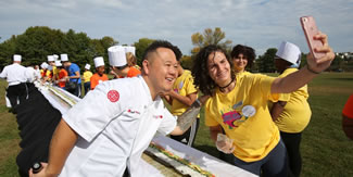Purchase College students and staff break a record for the world's longest California roll overseen by Food Network's celebrity chef Jet Tila Oct. 11, 2017 in Purchase. The mega maki required approximately 500 cups of vinegared rice, 800 sheets of nori paper, 125 avocados and 200 pounds of surimi, a fish paste.