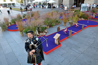 : Bagpiper Charles Rutan of Philadelphia plays the pipes next to a miniature golf course set up as part of "the world's largest putting green" event at Dilworth Park at City Hall. A 104 foot and 2 inch putting green at Dilworth at which former Eagle Hollis Thomas helped set a World Record was part of the event. The event was sponsored by The Famous Grouse, Scotland's number one Scotch.