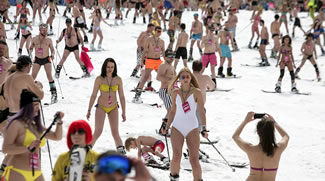 Skiers and snow boarders descend from a slope as they attempt to break the record for mass skiing in swimming suits at Rosa Khutor resort near Sochi, Russia.