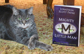 Little Man, crossing his paws in a characteristic pose, tolerates having his photo made with the book his owner, Madison, Ala., engineer Jonathon Scott Payne, has written about their lives together. 