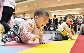 Babies compete in a crawling competition, hosted by a Japanese magazine that specialises in pregnancy, childbirth and child rearing, in Yokohama yesterday. The competition was held to challenge the Guinness World Record for the largest crawling competition.
