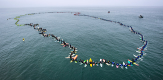  511 surfers joined hands today just off the pier in Huntington Beach, setting a World Record for the largest paddle out.